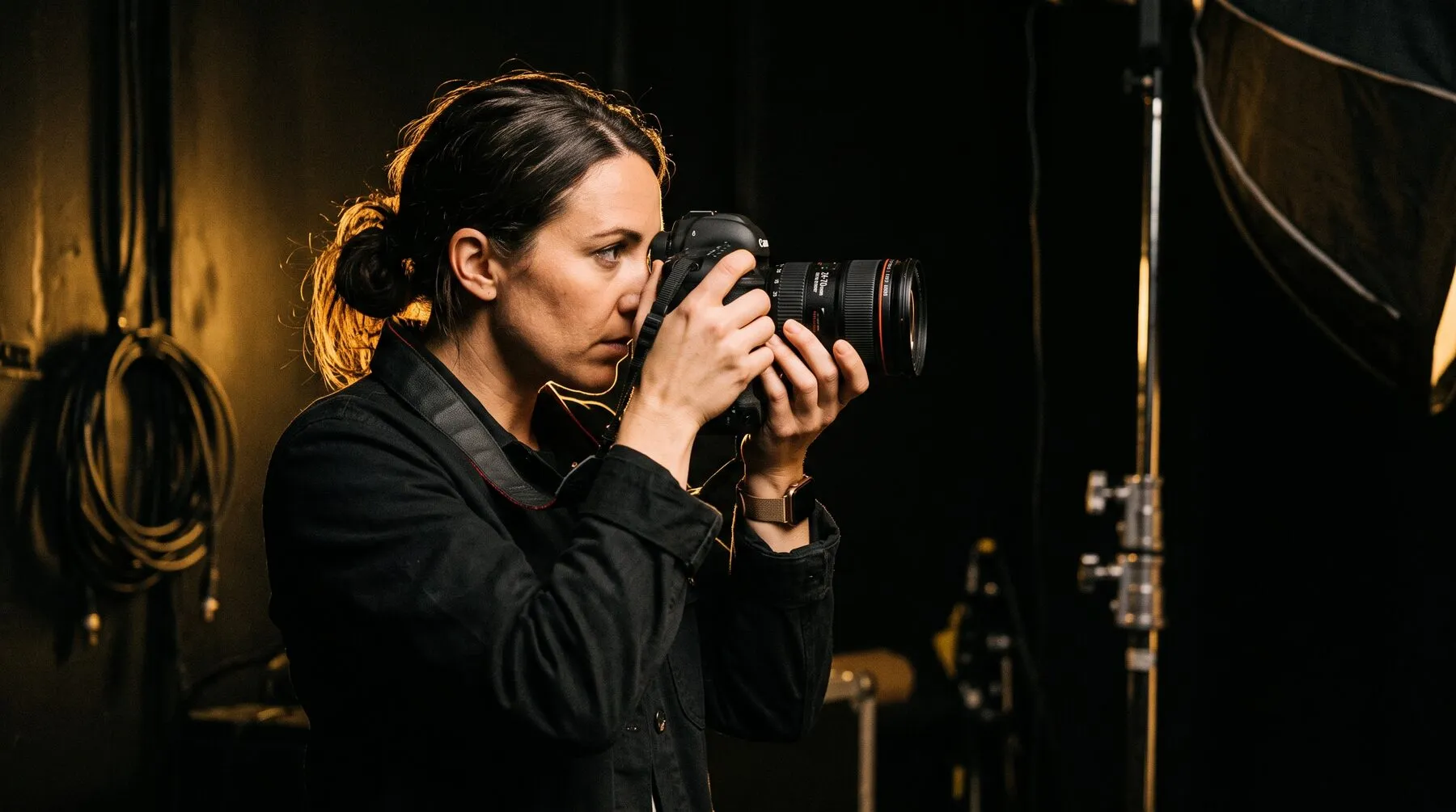A Click Production photographer shooting in the studio, lit with warm gold rim light